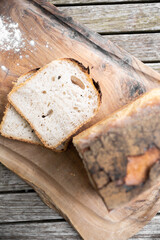 white tin bread loaf and slices on olive wood chopping board