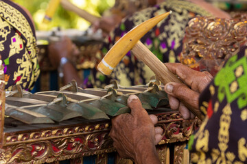 A musician plays a selantan or demong, a traditional Balinese instrument, as part of a musical...