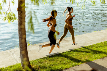 Young woman taking running exercise by the river promenade © BGStock72