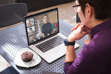 Aziatische zakenman die laptop in café gebruikt tijdens videoconferentie met multiraciale collega& 39 s