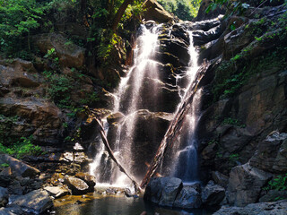 Rays of light breaking through a waterfall in the forest in Karnataka India