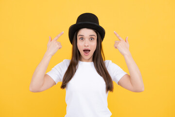 Excited amazed surprised face. Woman in magician top hat, black vintage cylinder cap on yellow...