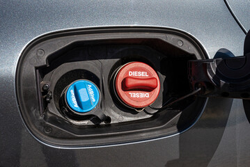 Fuel filler flap open with red diesel cap and blue adblue, the fuel filler caps are closed.