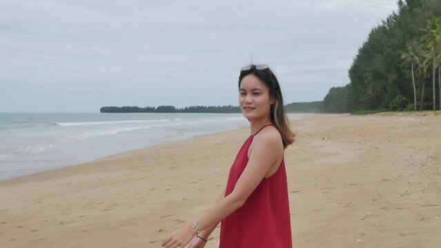 A young asian woman walk on the beach and relax while on holiday vacation