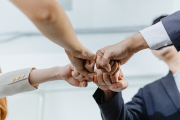 business team joins hands to show the power of doing business together.