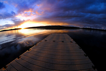 Obraz na płótnie Canvas Lake at Sunset or Sunrise with Dock Floating in Water