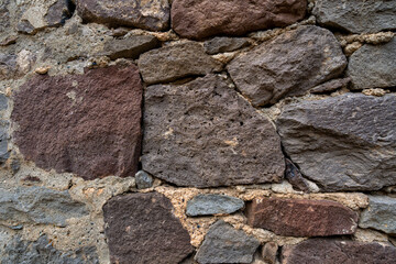 Stone wall with abstract pattern under sunlight.