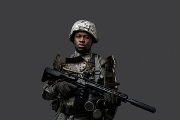 Fototapeta na wymiar Shot of special forces soldier of african descent dressed in camouflage clothes holding rifle.