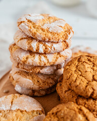 Close up of stack of almond cookies on wooden board.