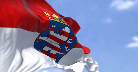 The flag of Hesse waving in the wind on a clear day. - obrazy, fototapety, plakaty