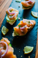 Close-up of smoked salmon on a baguette with cream cheese, cucumber, pickled red onion and fresh dill
