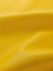 close up of yellow artificial leather with waves and folds on PVC base