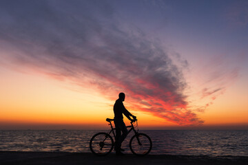 Fototapeta na wymiar man on bike silhouette on the beach 