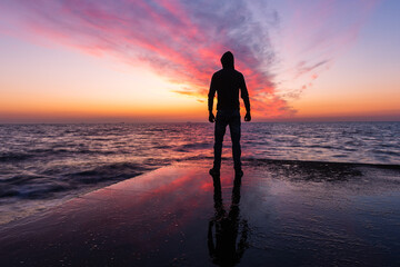 Ocean's Solace: Silhouetted Man in a Hood