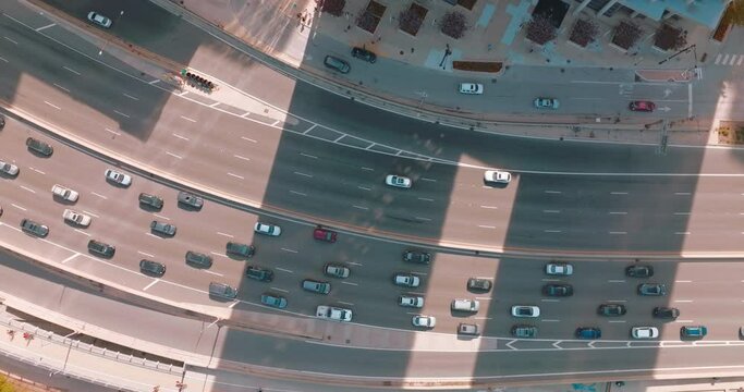 Quick and busy traffic on the wide-lane roads of Chicago. Birds' eye view on the highway between skyscrapers and green park.
