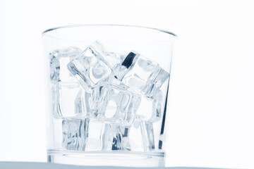 glass with ice cubes on white