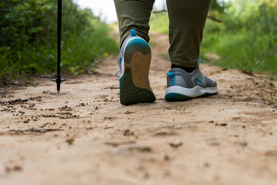 rear view of a woman's feet walking along a path in the countryside