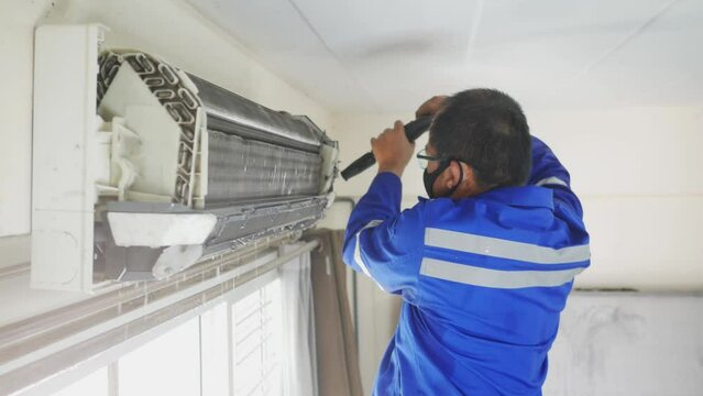 The air conditioning system in the house is being inspected and cleaned by a maintenance specialist.