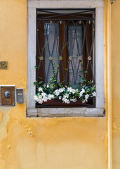 old window with shutters and flowers in Italy