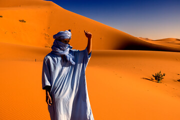 Hombre con chilaba azul en el desierto del Sahara