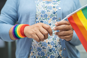 Asian lady with rainbow flag heart, symbol of LGBT pride month celebrate annual in June social of gay, lesbian, bisexual, transgender, human rights.