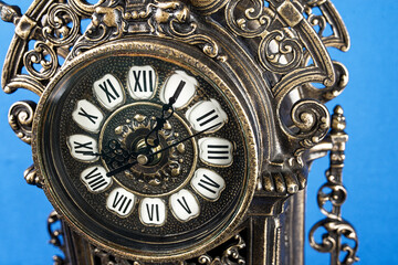 dial of vintage bronze clock, antique clock photo close up, old bronze clock in gilding, front of bronze fireplace clock