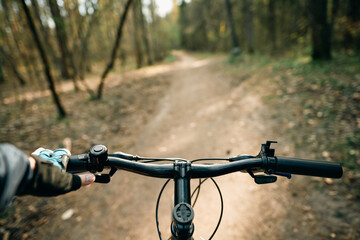 Top view of mountain bike handlebar and blurred cross country forest road. Concept of extreme...