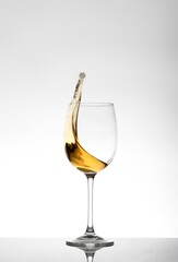 Splash of white wine in isolated glass on white background,