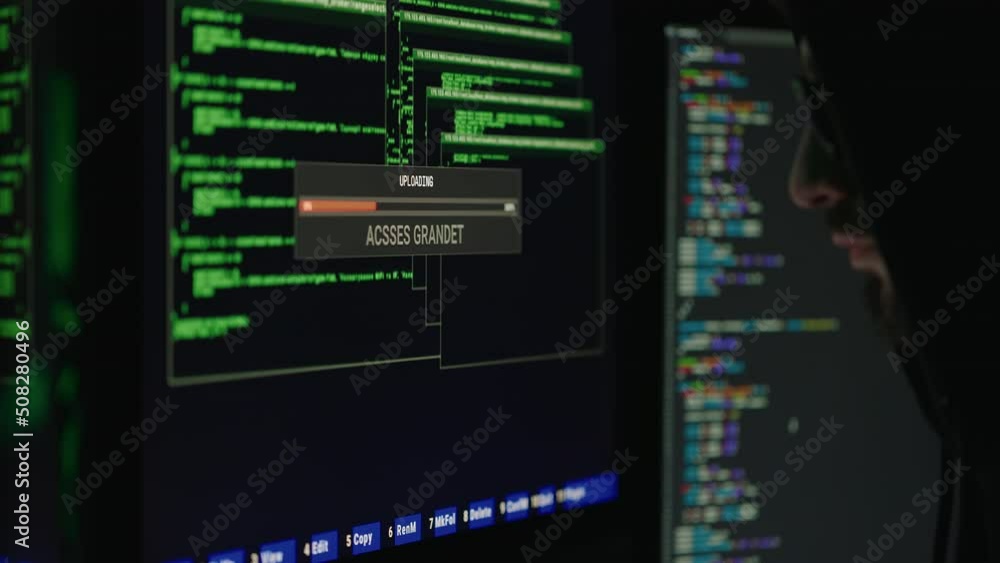 Wall mural dangerous hooded computer genius cracking database in dark room. side view of cybercriminal getting 
