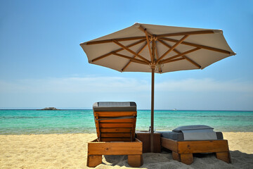 luxurious sunbeds and umbrella on beautiful beach