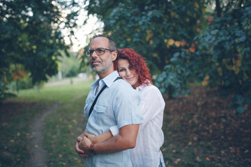 Cute middle aged european couple hugging in the park