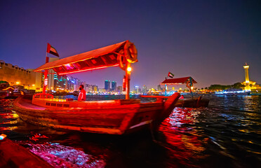 Abra boats on Dubai Creek in bright lights, UAE