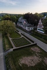 Fototapeta na wymiar Aerial views of a green area with German type houses, during sunset. 