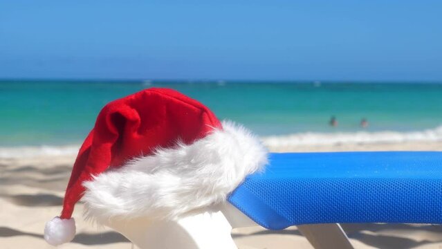 Santa Claus Hat on sandy beach. Tropical New year celebration. Nobody