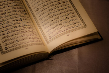 Al-Quran is a holy book of Islamic guidance isolated. religion concept. open a page of the Quran on...
