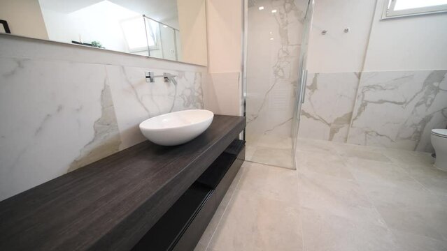 Spacious bathroom in gray tones with heated floors, walk-in shower and sink vanity. Modern bathroom interior