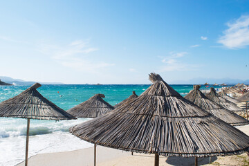 Palm umbrellas against the backdrop of the beautiful emerald Ionian sea in the Albanian Maldives, Ksamil, Albania