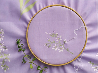 Vintage wooden embroidery hoops very peri color fabric with pattern for hand embroidery, flat lay © Kira_Yan