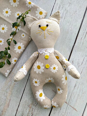 Cheerful linen textile toy cat by handmade, top view and sewing accessories, DIY flat lay