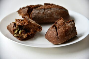 Pieces of black bread loaf on a white plate