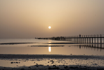 Fototapeta premium Wooden dock at the lake, sunrise at the sea