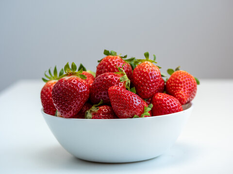 photo of a ripe stawberries in a white bowl.