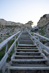 Fototapeta na wymiar Wooden staircase leading from the mountains to the sea. Paradise place for tourism and recreation. Hiking.