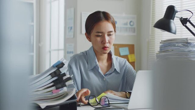 Tried young Asian office employee feeling sick and have a headache from a long working day at office