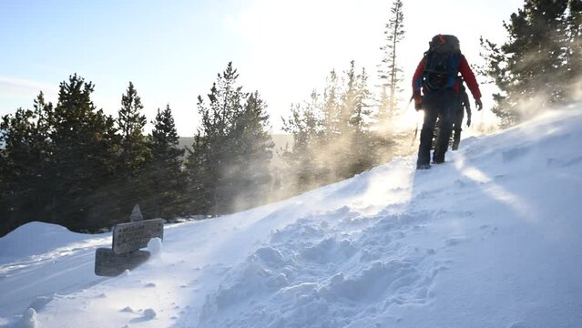 Hiking uphill in wind and snow in the winter at Rocky Mountain National Park