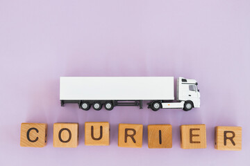 Toy truck with wooden box on purple background. Courier