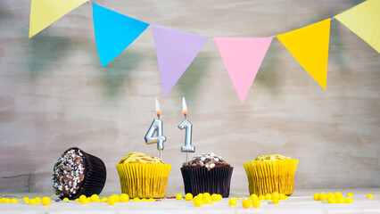 Birthday background with number 41. Beautiful birthday card with colorful garlands, a muffin with a...