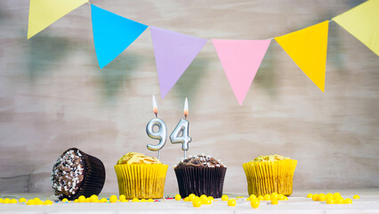 Birthday background with number 94. Beautiful birthday card with colorful garlands, a muffin with a...
