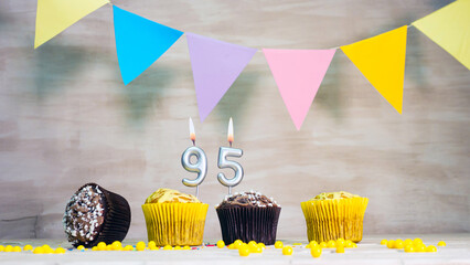 Birthday background with number 95. Beautiful birthday card with colorful garlands, a muffin with a...