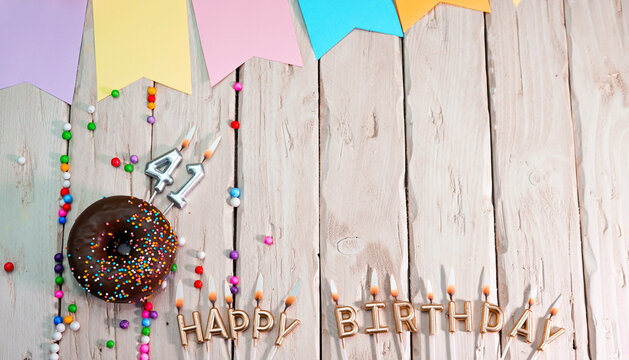 Birthday with number 41. Donut on the festive table. Happy birthday congratulations top view. Happy birthday card with beautiful decorations on a white board table.